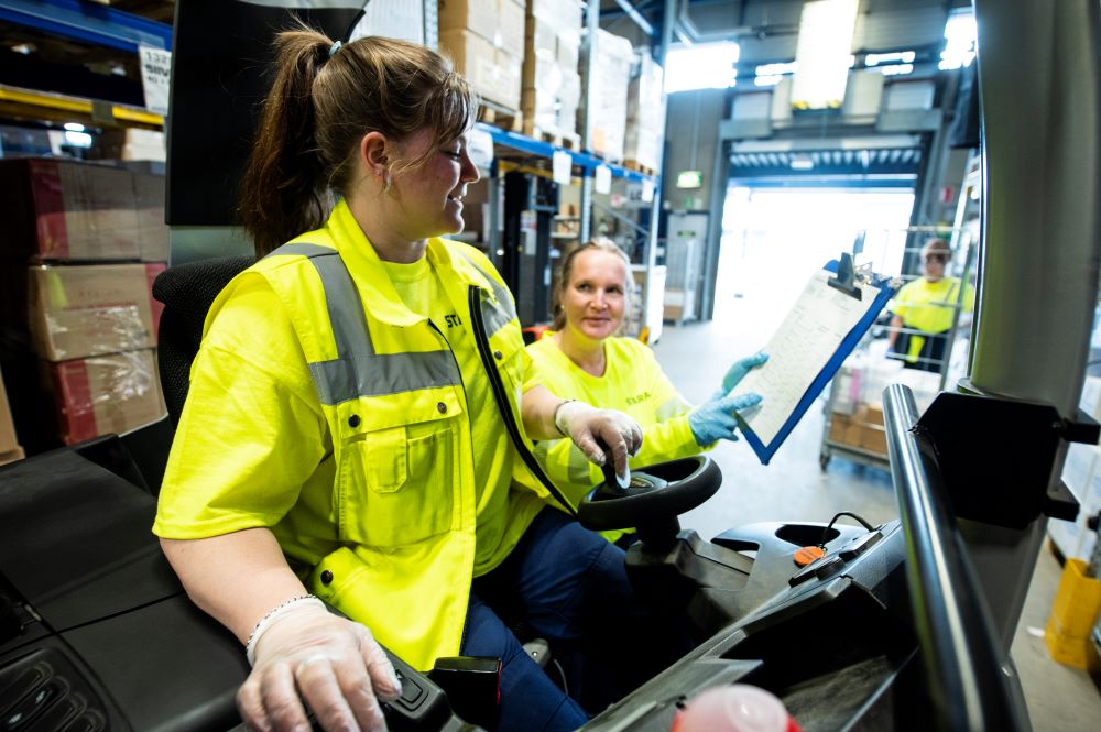 "Kaksi naista työskentelemässä logistiikkakeskuksessa."